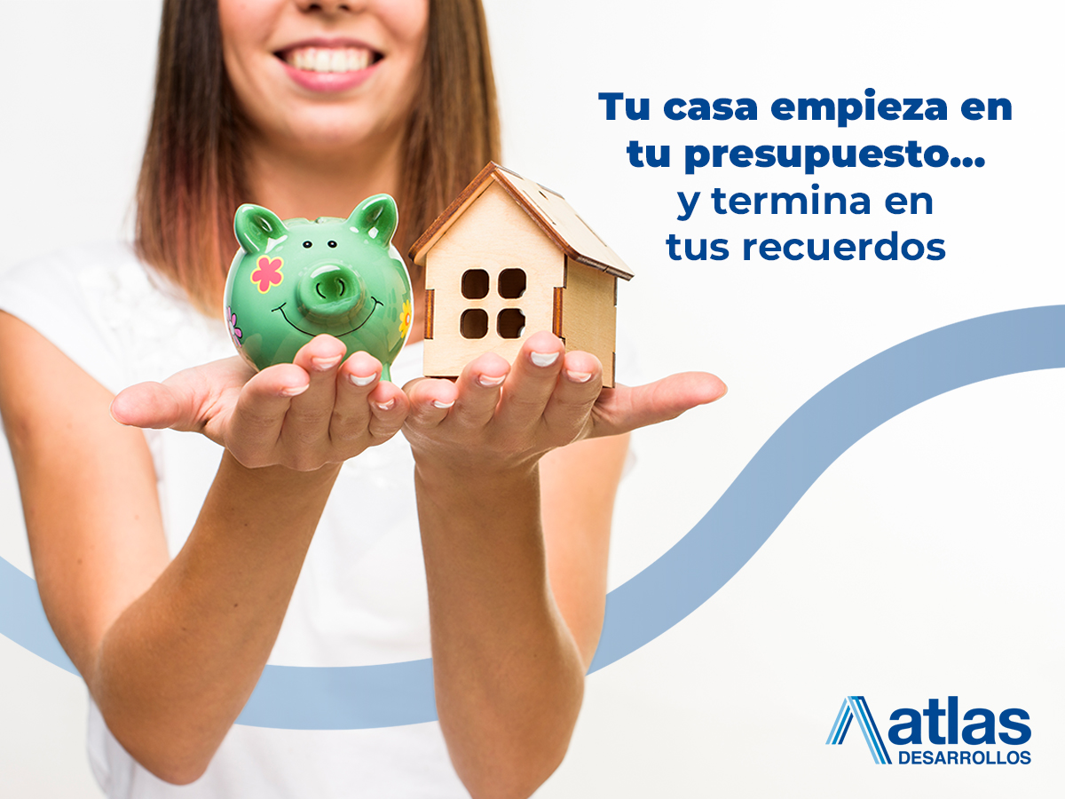 Mujer sonriente sosteniendo una alcancía y una casa en miniatura, simbolizando financiamiento para una casa con Atlas Desarrollos.